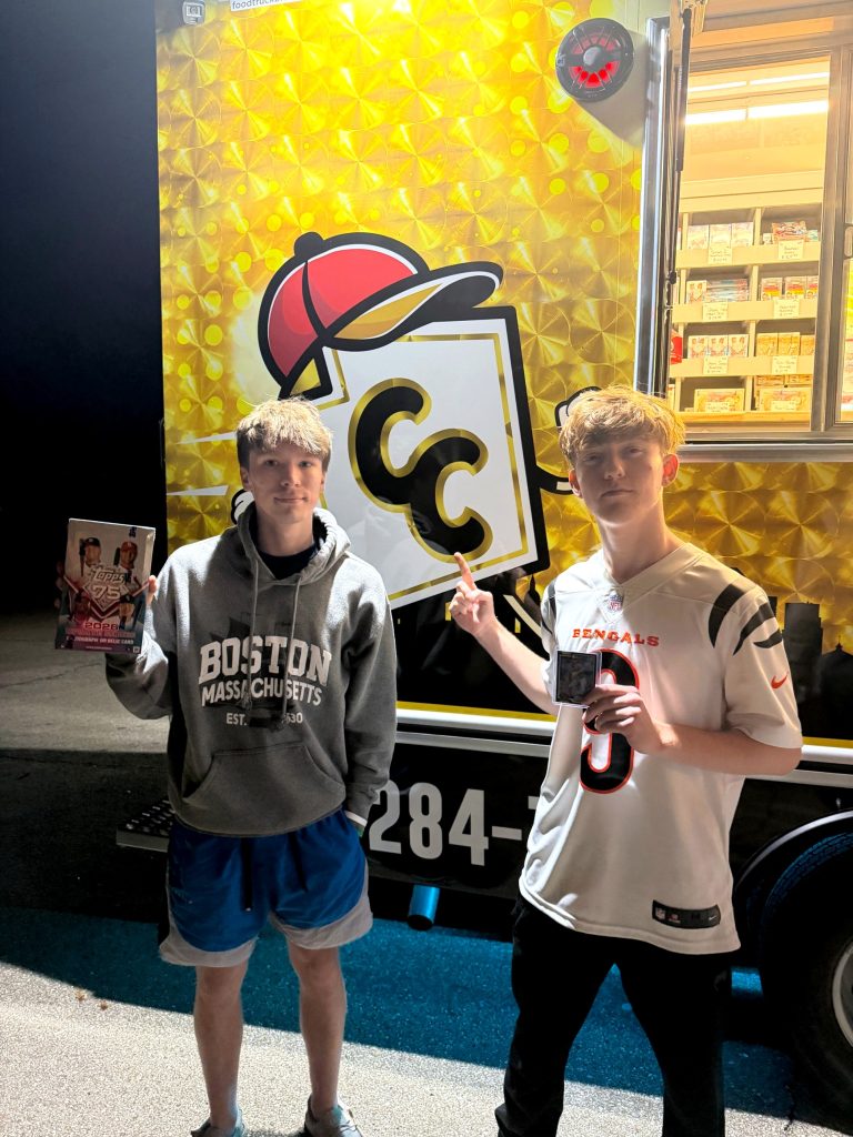 Two collectors holding the hobby box they won at the Card Chase launch night